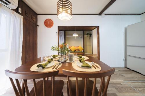 a dining room with a wooden table and chairs at Neuk Nakanosima in Ikuta