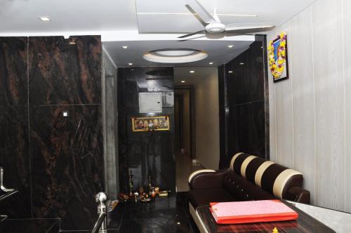 a living room with a couch and a ceiling fan at Ganga Residency Tiruvannamalai in Tiruvannāmalai