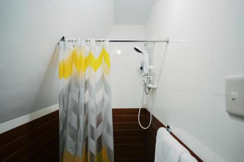 a shower with a yellow and white shower curtain at Ginadel Agritourism Park in Sampong