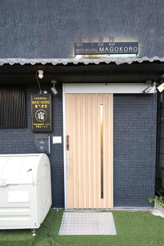 a front door of a building with a sign and a garage at NAMBA STAY 302 新今宮 Shiimamiya in Osaka
