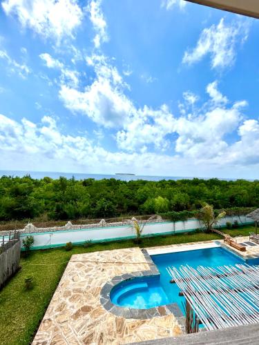 a swimming pool with a view of the ocean at Alcyone Residence - Ocean View Villa in Muyuni