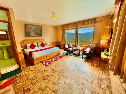 a bedroom with a bed and a living room at Hotel Hollywood Manali - Scenic River & Mountain View With Premium Rooms Near Mall Road in Manāli