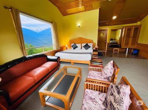 a living room with a bed and a couch at Hotel Hollywood Manali - Scenic River & Mountain View With Premium Rooms Near Mall Road in Manāli