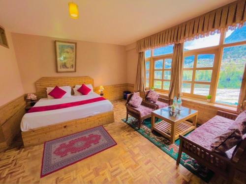 a bedroom with a bed and a couch and a table at Hotel Hollywood Manali - Scenic River & Mountain View With Premium Rooms Near Mall Road in Manāli