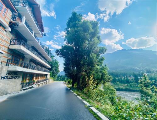 an empty road with a tree on the side of a building at Hotel Hollywood Manali - Scenic River & Mountain View With Premium Rooms Near Mall Road in Manāli