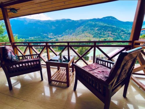 a balcony with chairs and a view of a mountain at Hotel Hollywood Manali - Scenic River & Mountain View With Premium Rooms Near Mall Road in Manāli