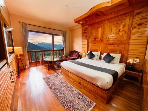 a bedroom with a bed and a large window at Hotel Hollywood Manali - Scenic River & Mountain View With Premium Rooms Near Mall Road in Manāli
