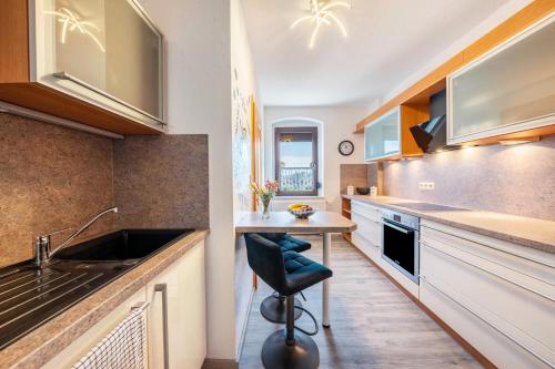 a kitchen with a sink and a table with a chair at Freundliche 50m² Ferienwohnung 