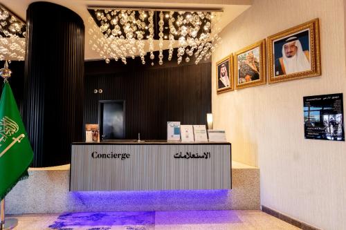 a lobby with a counter with purple carpet at Ramada Hotel & Suites by Wyndham Al Qassim in Al Bukayriyah