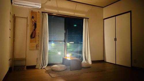 a room with a candle on a table in front of a window at KeiCo in Narusawa