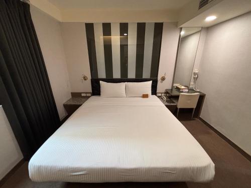 a large white bed in a hotel room at Fu Kuang Hotel in Pingtung City