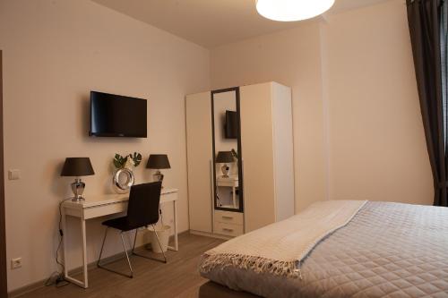 a bedroom with a bed and a desk and a television at Hotel Ravene in Cochem