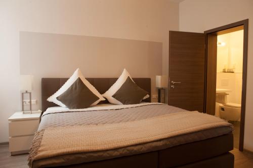 a bedroom with a large bed with pillows on it at Hotel Ravene in Cochem