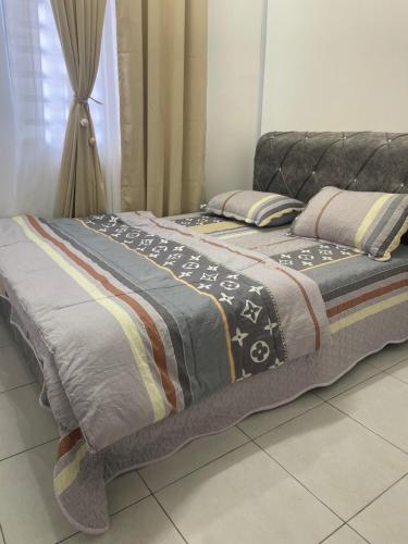 a bed with a blanket on it in a room at Homestay Cikgu Ina in Kampong Chepor