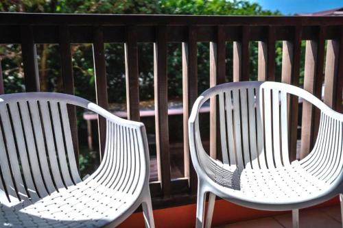 two white chairs sitting on top of a balcony at Ratana Hotel Chalong in Rawai Beach