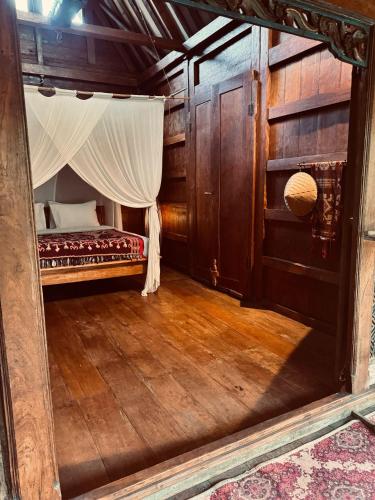 a room with a bed with a curtain in it at Resort JUNGLEROOM Canggu in Canggu