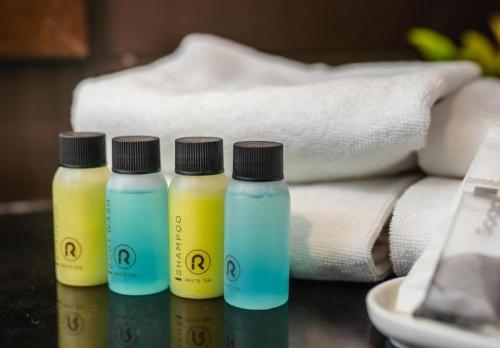 three bottles of liquids sitting on a table with towels at Ratana Hotel Chalong in Rawai Beach