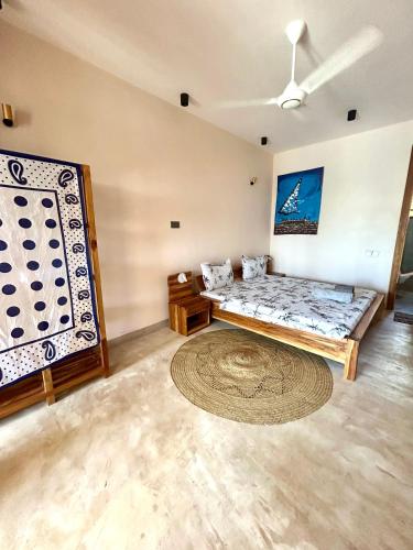a living room with a bed and a rug at Alcyone Residence - Ocean View Villa in Muyuni