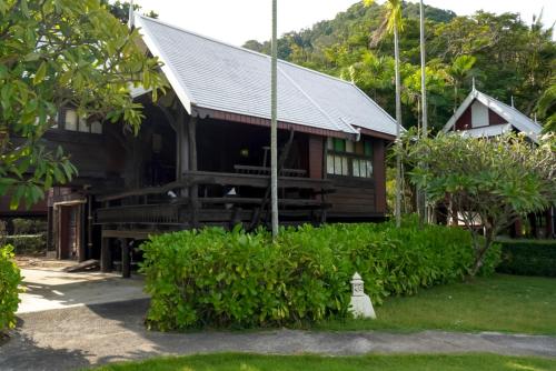 a wooden house with a gambrel roof at Baan Thong Ching Resort in Khanom