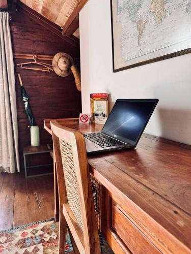 a laptop computer sitting on top of a wooden desk at Resort JUNGLEROOM Canggu in Canggu