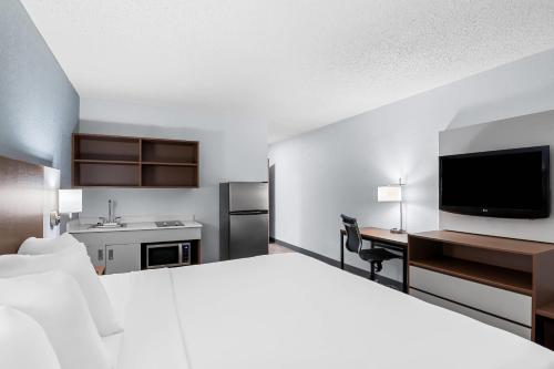 a hotel room with a bed and a desk and a tv at Suburban Studios Chester I-95 in Chester