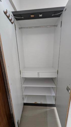 a closet with white walls and white shelves at Jalsa Home Stay in Sheoganj