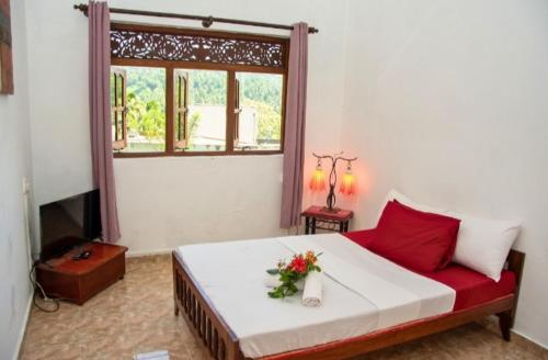 a bedroom with a bed with a flower arrangement on it at The Kingston Court in Kandy