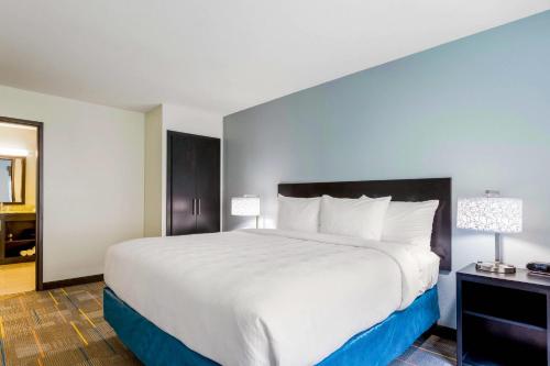 a large white bed in a hotel room at MainStay Suites Winfield-Teays Valley in Hurricane