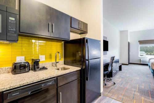 a kitchen with a stainless steel refrigerator and a sink at MainStay Suites Winfield-Teays Valley in Hurricane