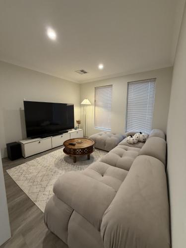 a living room with a couch and a flat screen tv at 12 Beautiful Brabham Big Backyard 4br Parking in Perth
