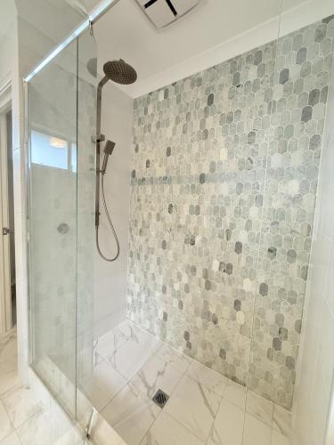 a shower with a glass door in a bathroom at 12 Beautiful Brabham Big Backyard 4br Parking in Perth