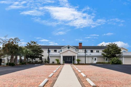 Casa blanca grande con entrada de ladrillo en The Port Inn and Cottages, an Ascend Collection Hotel, en Port Saint Joe