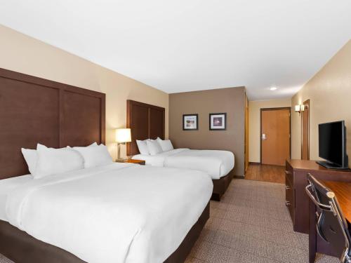 a hotel room with two beds and a flat screen tv at Comfort Inn & Suites Munising-Lakefront in Munising