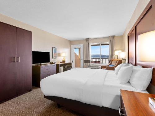 a hotel room with a large bed and a television at Comfort Inn & Suites Munising-Lakefront in Munising