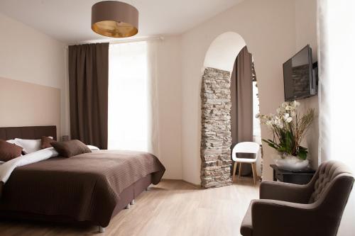 a bedroom with a bed and a chair at Hotel Ravene in Cochem