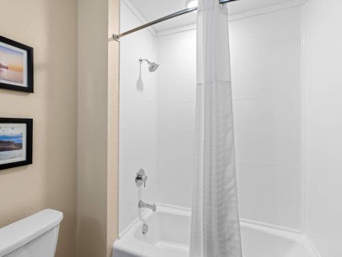 a bathroom with a shower with a white tub at Comfort Inn & Suites Munising-Lakefront in Munising