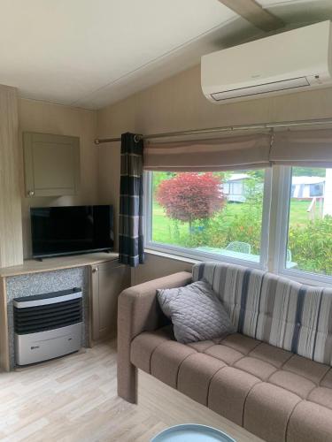 a living room with a couch and a window at Chalets van Minicamping De Braamhof in Koudekerke