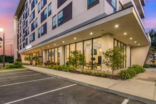 a building with a lot of windows in a parking lot at Cambria Hotel Orlando near Universal Theme Parks in Orlando