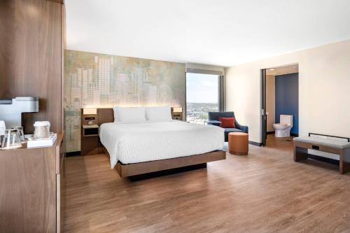 a hotel room with a bed and a bathroom at Cambria Hotel Orlando near Universal Theme Parks in Orlando