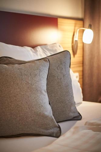 a bed with a pillow and a lamp on it at Appartements Der Fuchsbau in Saalbach Hinterglemm