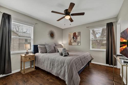 Un dormitorio con una cama y un ventilador de techo. en Cora Street Cottage, en Fredericksburg