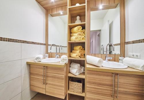 a bathroom with two sinks and a mirror at Appartements Der Fuchsbau in Saalbach Hinterglemm
