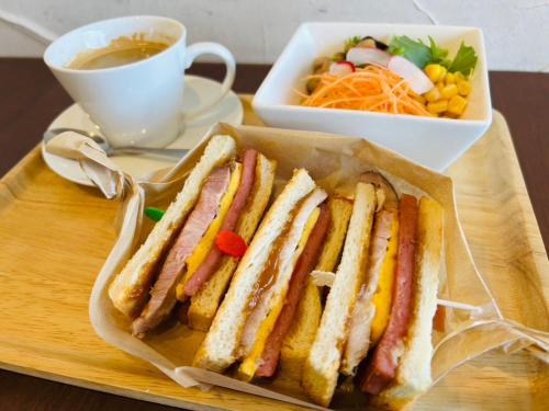 einen Teller Sandwiches und eine Tasse Kaffee in der Unterkunft GLORY ISLAND OKINAWA Yabusachi Resort in Nanjō