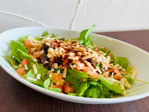 eine weiße Schüssel mit Salat auf dem Tisch. in der Unterkunft GLORY ISLAND OKINAWA Yabusachi Resort in Nanjō