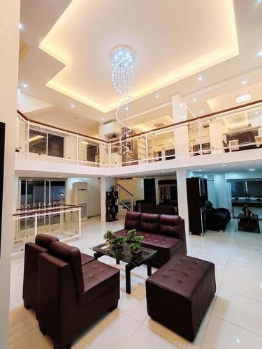 a living room with couches and a table in a building at 7BR Luxury Resort with Pool and Bar in Sampong