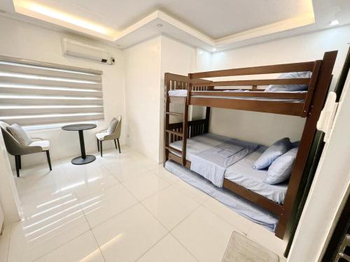 two bunk beds in a room with a table and chairs at 7BR Luxury Resort with Pool and Bar in Sampong