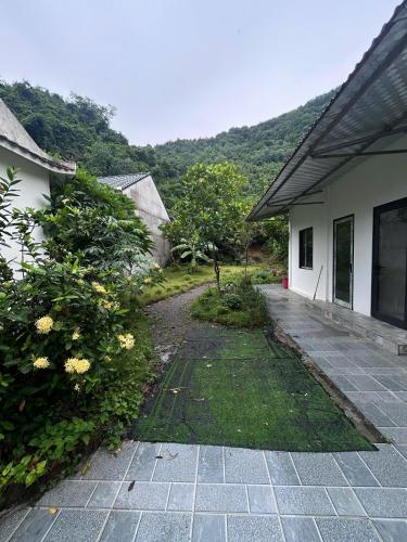 Una pasarela junto a una casa con montañas al fondo en Mellowmoo Homestay, en Nguyễn Thôn