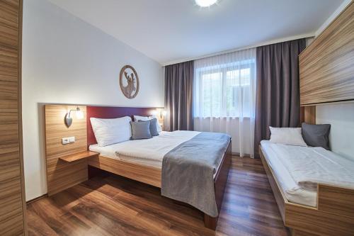 a hotel room with two beds and a window at Appartements Der Fuchsbau in Saalbach Hinterglemm