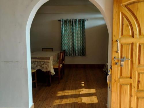 an archway leading to a dining room with a table at Wanderlust Homestay By StayApart in Kalimpong
