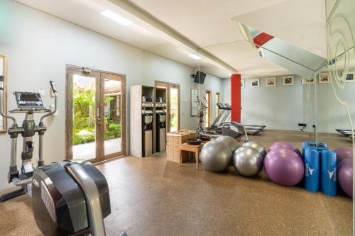 a gym with a bunch of equipment in a room at Rama Residence Petitenget in Seminyak